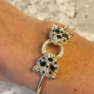 Gold color metal bracelet with green stones.